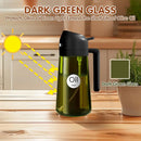 Dark green glass oil bottle with black lid on a wooden surface, kitchen background.