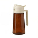 Brown glass bottle with beige cap and handle on a white background