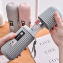 Gray striped toothbrush holder with a toothbrush inside, held by hands on a wooden surface.