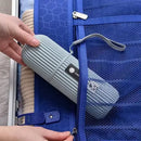 Person placing a gray travel mat into a blue suitcase