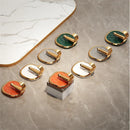 Decorative wall hooks with gold accents on a marble surface