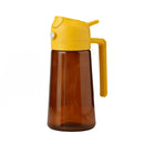 Brown glass bottle with yellow cap and handle on a white background