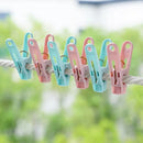 Pastel-colored clothespins on a rope with a blurred green background
