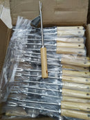 A set of metal skewers with light wood handles, some unpacked and wrapped in clear plastic, arranged inside an open cardboard box.